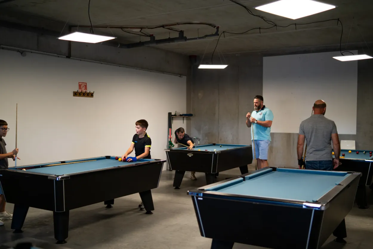 Jeunes et adultes jouant au billard anglais dans la salle du Poitiers Billard Club